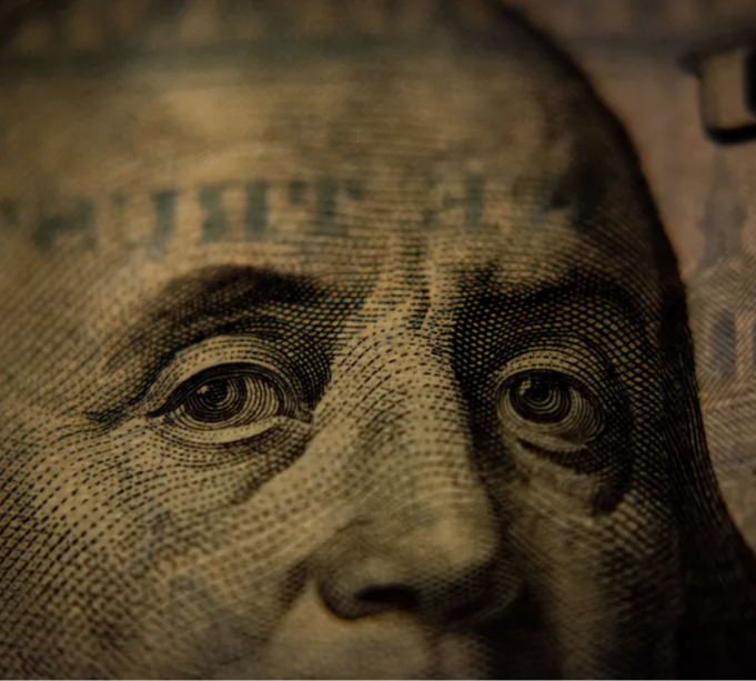 Dinheiro: nota de 100 dólares, focando o rosto de Benjamin Franklin. Foto: AdamNir/Unplash